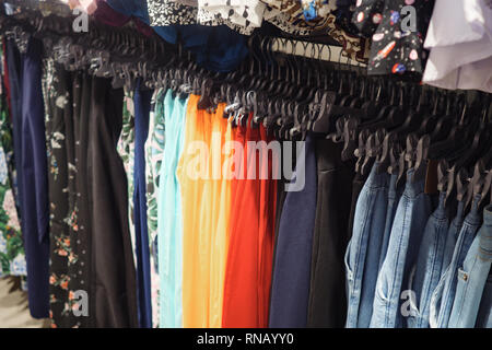 Rack avec cintres de métal à la mode colorée en pantalon boutique contemporain Banque D'Images