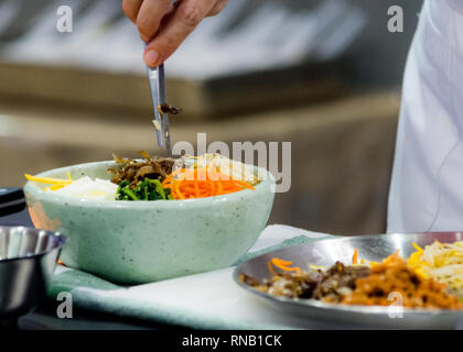 Une cuisine traditionnelle coréenne Bibimbap, bibimbap, Chef de la préparation de la nourriture coréenne, chef cooking in kitchen Banque D'Images