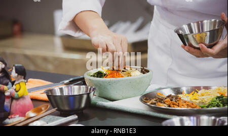 Une cuisine traditionnelle coréenne Bibimbap, bibimbap, Chef de la préparation de la nourriture coréenne, chef cooking in kitchen Banque D'Images