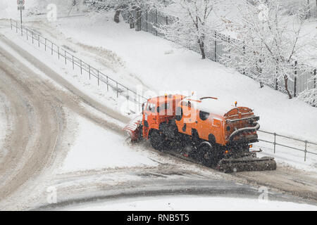 Chasse-neige ou camion Orange Street Sweeper machine nettoie la surface de la route de la neige. Neige Février Banque D'Images