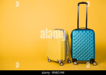 Des sacs de voyage jaune et bleu sur fond jaune Banque D'Images