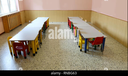 Grande pièce utilisée comme pépinière un réfectoire avec tables et petites chaises sans enfants Banque D'Images