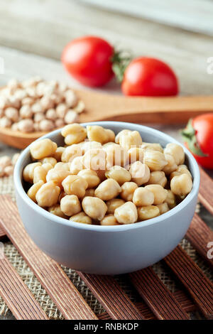 Cuire les pois chiches (Cicer arietinum) dans un bol sur fond de bois Banque D'Images