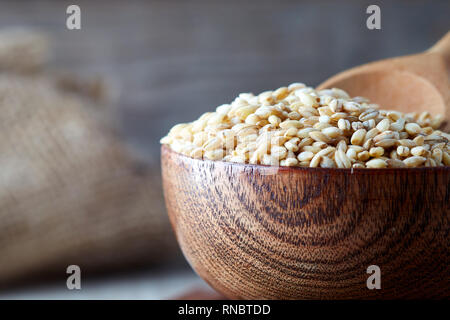 Les grains d'orge (Hordeum vulgare) dans bol en bois. Copy space Banque D'Images