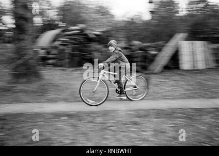 Neuf ans boy riding a bike, Hattingley, Medstead, Alton, Hampshire, Angleterre, Royaume-Uni. Banque D'Images