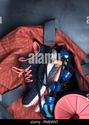 Chaussures de sport, sac sur tshirt, rouler pour la presse, sur fond noir en gris,copy space Banque D'Images