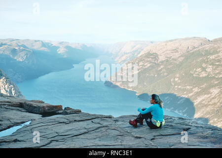 Une fille se repose et randonneur profitant de la vue sur le haut de l'Pulpit Rock / Prekestolen Preikestolen ou en Norvège Banque D'Images