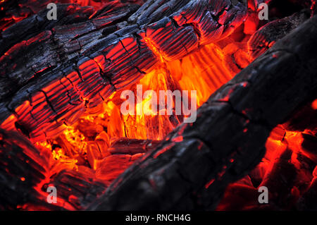 Belle couleur de la combustion des charbons rouge et noir bois carbonisé. Charbons chauds orange Banque D'Images