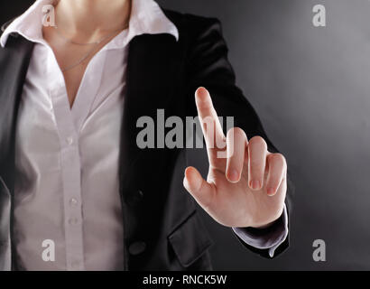 Close up. business woman appuie sur un bouton virtuel.isolé sur fond noir Banque D'Images