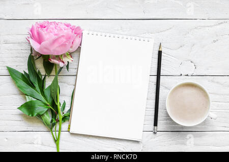 Womens day ou mariage contexte. le papier vierge et carte fleur de pivoine avec cappuccino blanc sur la table en bois. Mise à plat. top view with copy space Banque D'Images