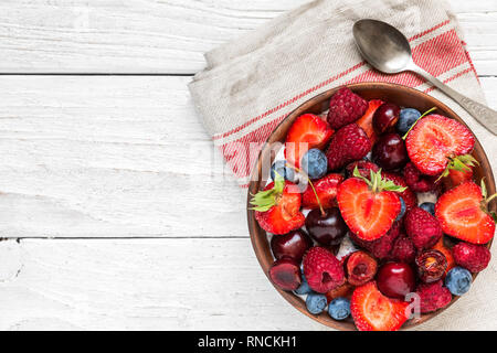 Petit-déjeuner sain bol de fruits et de baies avec du yogourt ou chia pudding et cuillère. diet concept. top view with copy space Banque D'Images
