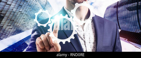 Businessman hand agissant sur groupe de roues dentées. Banque D'Images