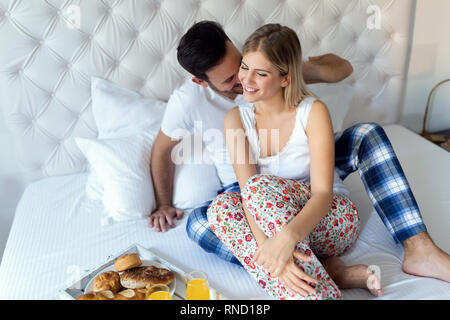 Young attractive couple having breakfast in bed Banque D'Images