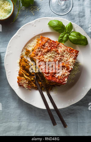 Lasagne vegan avec les lentilles et les pois verts dans une plaque sur une table avec une nappe en lin bleu. Une cuisine italienne sain pour toute la famille, par Banque D'Images