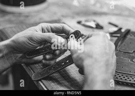 Professionnel hommes skinner, tanner travailler avec véritable cuir ceinture en atelier, studio. Et le travail du cuir fait main concept Banque D'Images