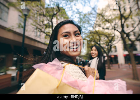 Deux femmes asiatiques en marche sac shopping street. Vue arrière d'une femme portant un panier et à l'arrière. Banque D'Images