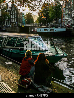 Amsterdam, Pays-Bas. 9 octobre, 2005. Deux jeunes femmes s'asseoir par un canal à Amsterdam, aux Pays-Bas. Credit : Arnold Drapkin/ZUMA/Alamy Fil Live News Banque D'Images