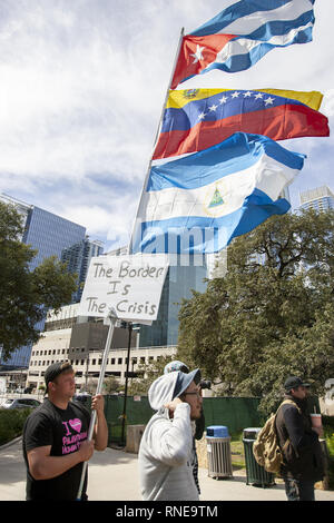 Austin, Texas, États-Unis. Feb 18, 2019. Un protestataire est titulaire d'un cours d'eau au large de drapeaux de Cuba au Venezuela, et d'El Salvador afin d'attirer l'attention sur l'appel de Trump Président une urgence nationale pour construire un mur le long de la frontière entre les États-Unis et le Mexique et son appel pour un changement de régime au Venezuela à la place de la République à Austin au Texas, le parc President's Day. Credit : Jaime Carrero/ZUMA/Alamy Fil Live News Banque D'Images