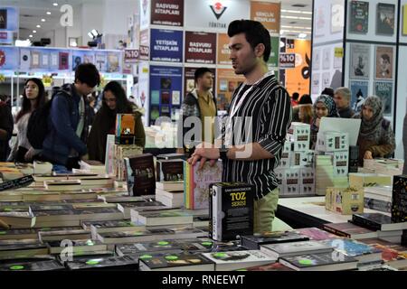 16 février 2019, Turquie, Ankara : un vendeur se tient derrière son livre se tenir à une foire du livre. La foire est un événement annuel qui se déroule pour la 13e fois, l'hébergement le plus important des éditeurs et des auteurs. Photo : Altan Gochre dans le monde d'utilisation | Banque D'Images