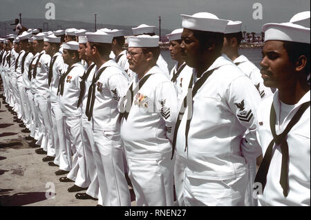 1982 - de l'équipage de la frégate lance-missiles USS LEWIS B. PULLER (FFG-23) s'élèvent à se reposer pendant le défilé pour la cérémonie de mise en service du navire. Banque D'Images