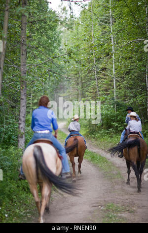 Les gens de l'équitation le long chemin forestier Banque D'Images