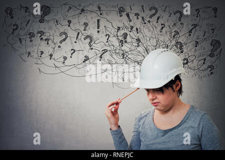 Young woman wearing ingénieur pensée casque de protection de tête, crayon de pointage a souligné à la sensation, épuisé. Maux de tête, l'anxiété Banque D'Images