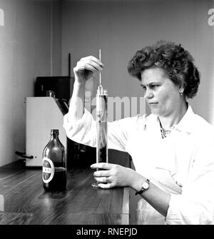 L'histoire de la Finlande Kotka - Brasserie à vapeur inspecteur inspecte la qualité de la bière en bouteille. ca. 1960 Banque D'Images