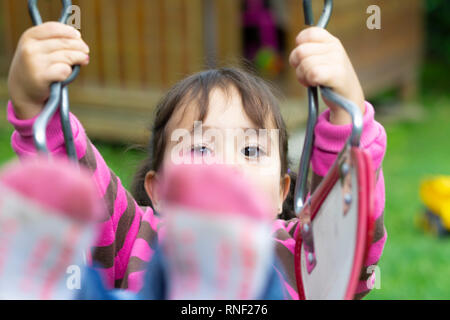 Heureux les enfants se balançant dans le parc Banque D'Images