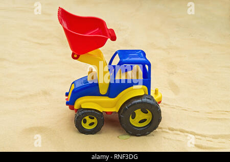 Tracteur jouet dans sandbox sur l'aire de jeux dans le parc de loisirs de la ville Banque D'Images