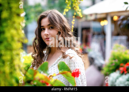 Jeunes, beaux, dark-haired woman portrait dans le parc de la ville au printemps. Copier l'espace. Banque D'Images