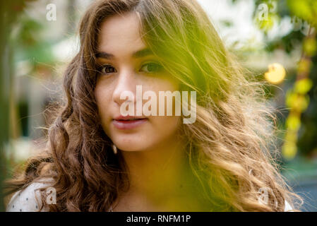 Jeunes, beaux, dark-haired woman portrait dans le parc de la ville au printemps. Banque D'Images