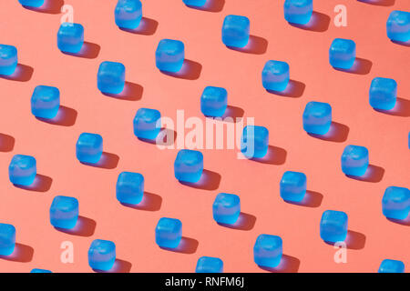Modèle de création lumière bleue avec des cubes de glace avec des ombres sur un fond d'une couleur de l'année 2019 de coraux vivants Pantone. Banque D'Images