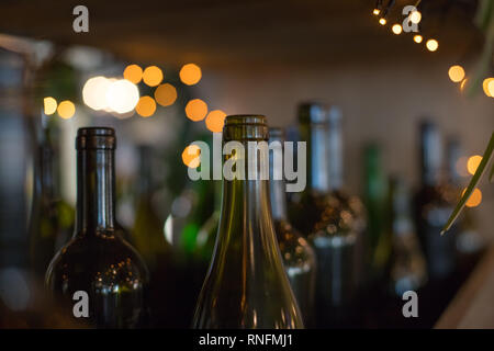 Éléments décoratifs en verre foncé de l'intérieur de bouteilles vides sur fond brillant.De nombreuses bouteilles de vin en verre comme un décor.comptoir bar. Décorée avec une série de Banque D'Images