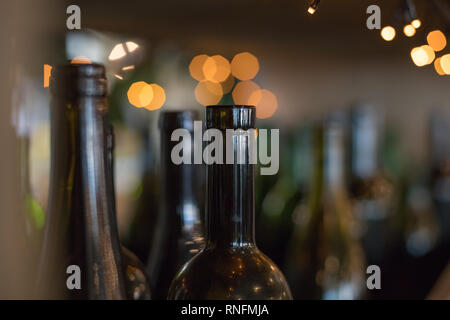 Éléments décoratifs en verre foncé de l'intérieur de bouteilles vides sur fond brillant.De nombreuses bouteilles de vin en verre comme un décor.comptoir bar. Décorée avec une série de Banque D'Images