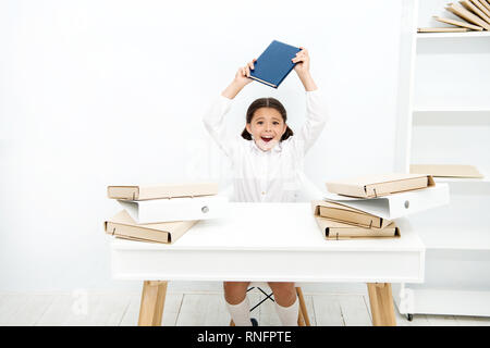 Dans l'humeur capricieuse. Mec être bruyant à l'école. Petit enfant qui refuse d'apprendre l'alphabétisation. Petite fille livre sensibilisation sur la tête. Angry girl reading book déteste. Lycéenne ayant leçon de littérature. Banque D'Images