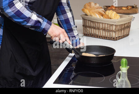 Un homme gras frites escalopes dans une casserole, beaucoup de gras, de la malbouffe, close-up Banque D'Images