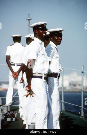 1981 - Les marins à bord de navires de patrouille de la Marine du Ghana homme ACIMOTA les rails comme ils l'escorter le destroyer USS ARTHUR W. RADFORD (DD-968) dans le port pour une visite de bonne volonté. Banque D'Images