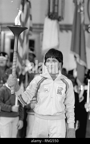 Premier porteur du flambeau olympique Sandy Norris, après son relais, s'établit à l'attention à la cérémonie d'arrivée de la flamme. La flamme, d'abord posé à Olympie, en Grèce, s'effectue dans une série de 52 relayeurs dans une course à relais de 1 000 milles de la base jusqu'à Lake Placid, New York, pour ouvrir le XIII Jeux Olympiques d'hiver. Banque D'Images