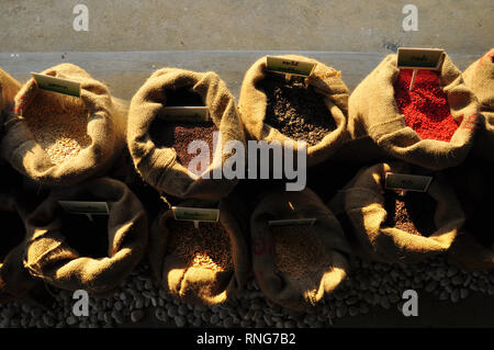Graines de moutarde, de lin, de tournesol et de coriandre sont déversées à partir de sacs de linge Banque D'Images