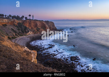 Point de vue de l'exposition longue Vicente Lighthouse au sommet des falaises escarpées de Rancho Palos Verdes, en Californie avec des vagues se brisant sur les rochers shor Banque D'Images