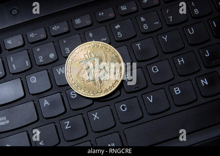 Close-up of a golden coin bitcoin sur un clavier qwerty clavier de bureau Banque D'Images