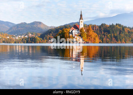 Vue d'automne du lac de Bled dans les Alpes Juliennes, en Slovénie. Église de pèlerinage de l'assomption de Marie sur un premier plan. Photographie de paysage Banque D'Images