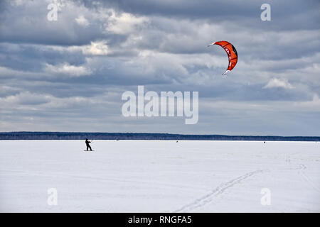 = Snow Kite Lac Plechtcheïevo  = une planche à neige avec un red kite-surf sur un lac Plechtcheïevo congelé à Pereslavl-zalesski sous un ciel gris. Ph Banque D'Images