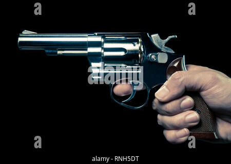 L'acier inoxydable ou d'armes à feu Vintage Shooter en vue du côté humain. Faux pistolet inox ou shooter dans la main vue portrait de la violence criminelle ou concept Banque D'Images