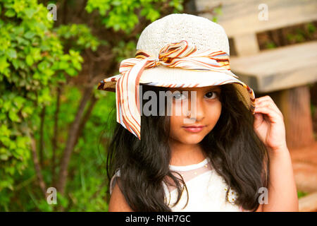 Petit Indian girl wearing cap fantaisie ronde looking at camera, Pune Banque D'Images
