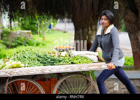 Jeune Indienne aux cheveux courts vendant des légumes sur un chariot, Pune Banque D'Images