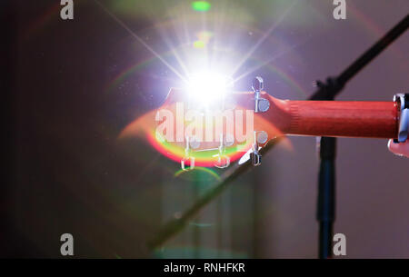 Corps d'une guitare acoustique sur fond de belle et naturelle bien arrondi. Vue arrière de la tête de la guitare au cours du spectacle. Rayons de soleil extrême vigueur. Banque D'Images