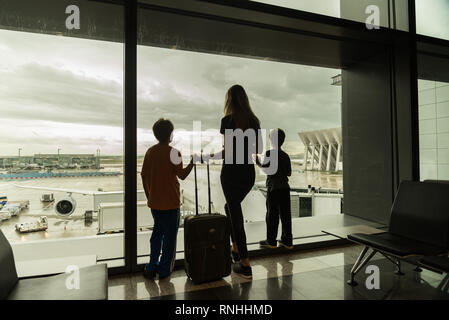 Silhouettes de maman avec les enfants dans le terminal en attente de Travel Concept vol Banque D'Images