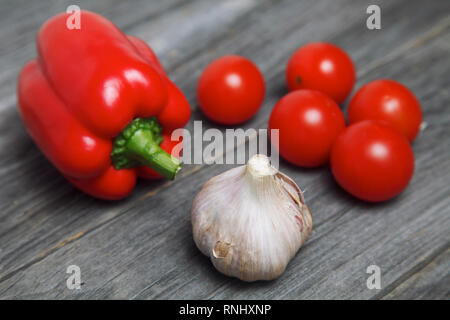 Se coucher sur une table en bois, l'ail, les poivrons et tomates fraîches Banque D'Images