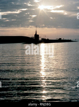 1982 - Un port bow view de la stratégique à propulsion nucléaire sous-marin USS OHIO (SNLE-726) silhouette sur le soleil couchant. Banque D'Images